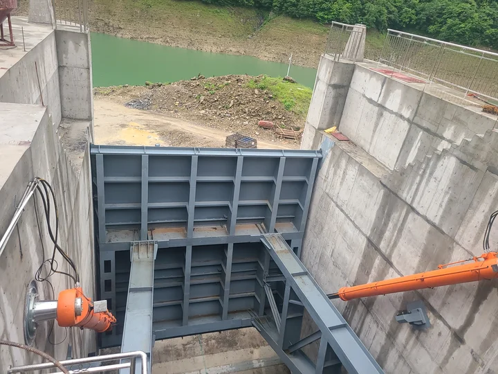 Radial gate installation showing support arms and hydraulic cylinders on both sides