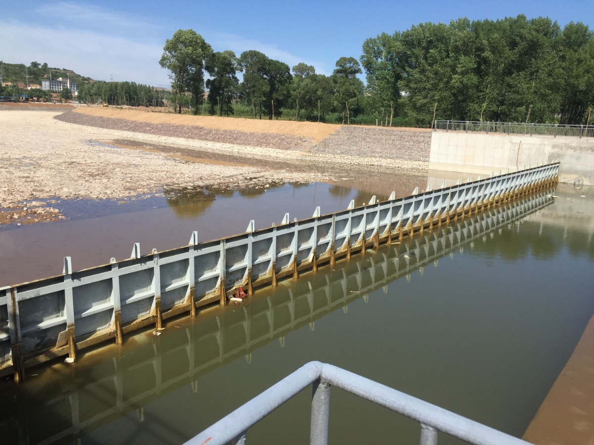 Steel dam gate spanning a river channel